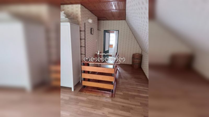 Padlásszoba fa mintázatú padlóval egy családi házban.