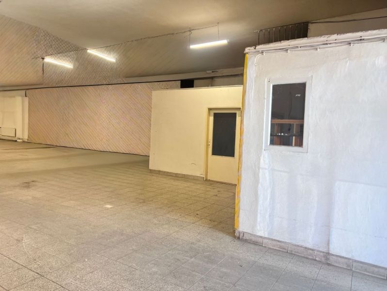 Raktárhelyiségek és csarnokok csempével és fehér falakkal, ideális tárolásra.