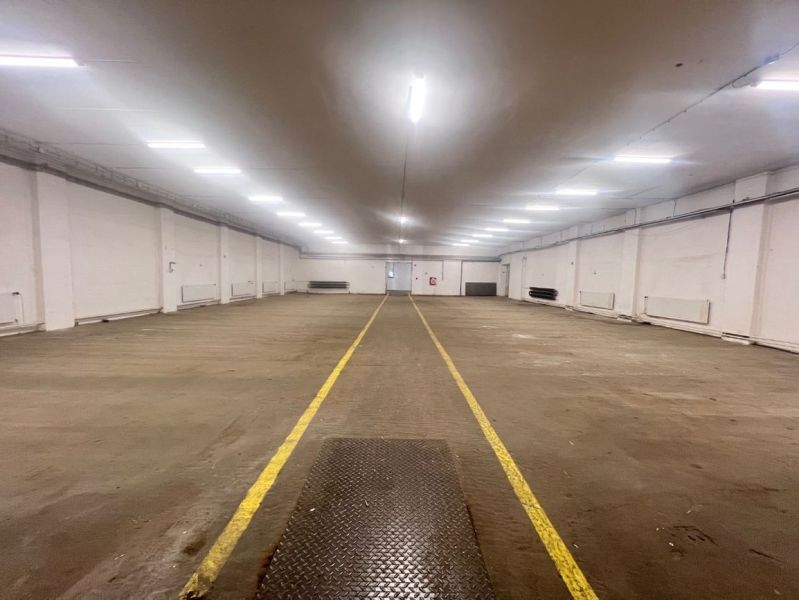 Széles raktár belső tér világítással és jelölt padlóval a raktárak és csarnokok területén.