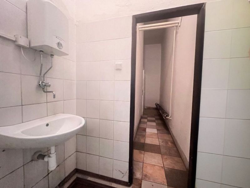 Fürdőszoba belső tér raktárakban és csarnokokban mosdóval és fali vízmelegítővel.
