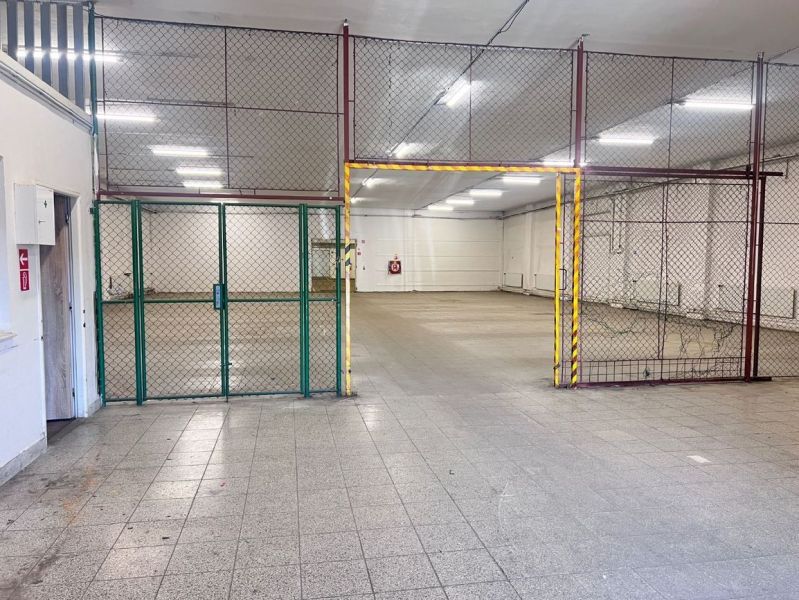 Raktárak és csarnokok belső tere csempével és fém kerítéssel.