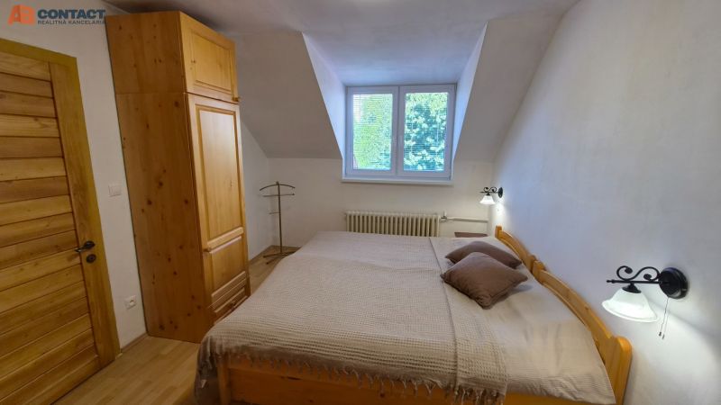 Hálószoba egy kétszobás lakásban fa bútorokkal és fa dekorációs padlóval.