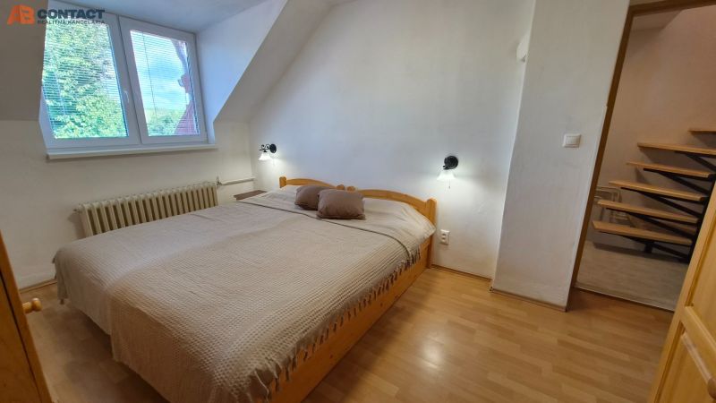 Hálószoba egy kétszobás lakásban franciaággyal és fa dekorációjú padlóval.