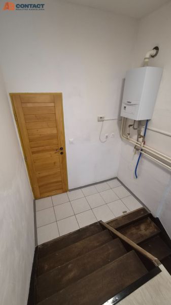 Lépcső fa lépcsőfokokkal és gázkazánnal egy kétszobás lakásban.