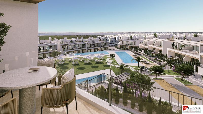 Kilátás egy torreviejai kétszobás lakás erkélyéről, medence és kinti napozóágyak.