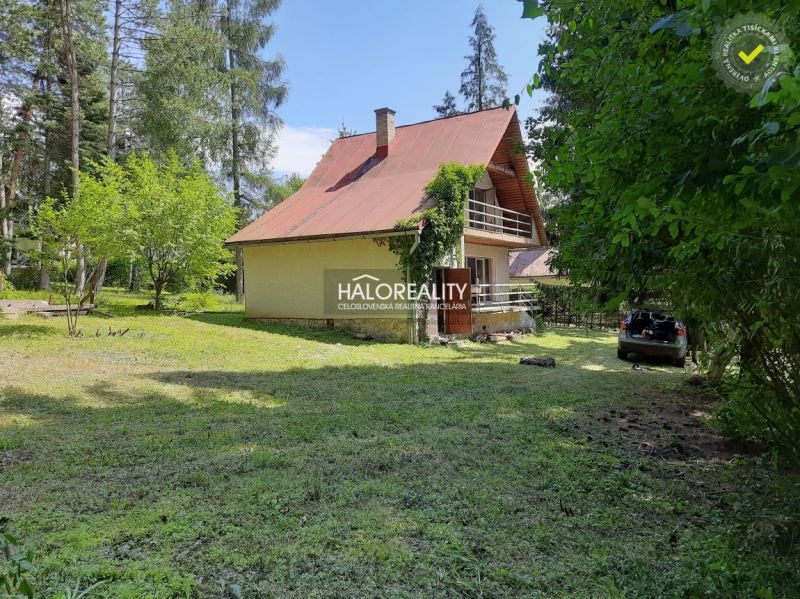 Házikó Ružinánál, fákkal és zölddel körülvéve, autóval a felhajtón.