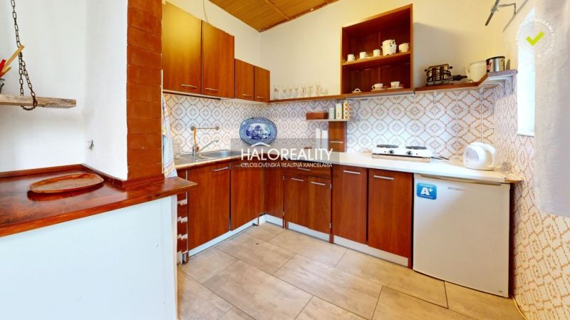 Konyha a faházban fa bútorokkal és mintás csempékkel a falakon.