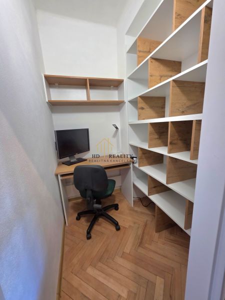 Dolgozósarok fa mintás padlóval és polcokkal egy kétszobás lakásban.