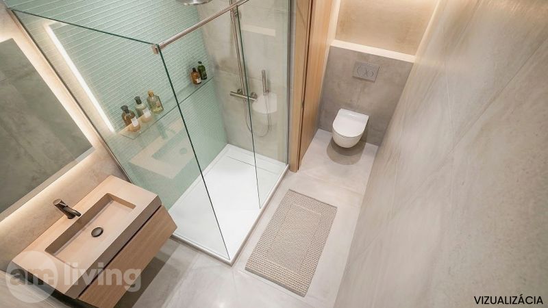 Fürdőszoba egy kétszobás lakásban zuhanyzóval, mosdóval, WC-vel és szőnyeggel.