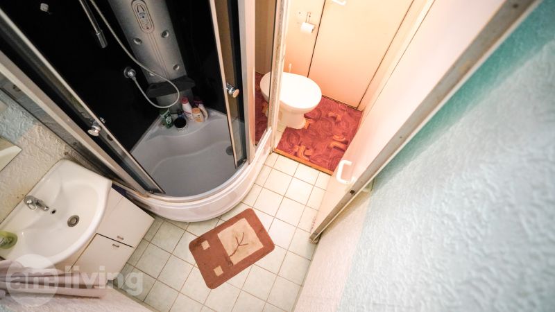 Kényelmes fürdőszoba egy kétszobás lakásban káddal, mosdóval és WC-vel.