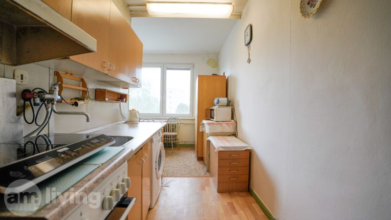 Konyha egy kétszobás lakásban, fa dekorációjú padlóval és alapvető felszereltséggel.