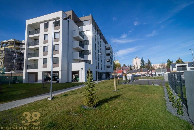 Egy lakóház Poprádon zöld gyepes területtel és a háttérben szomszédos épületekkel.