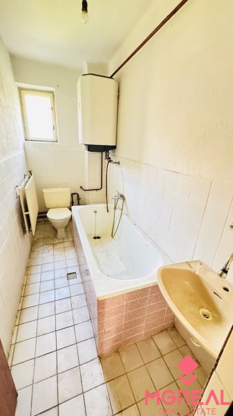 Fürdőszoba családi házban káddal, mosdóval és WC-vel.