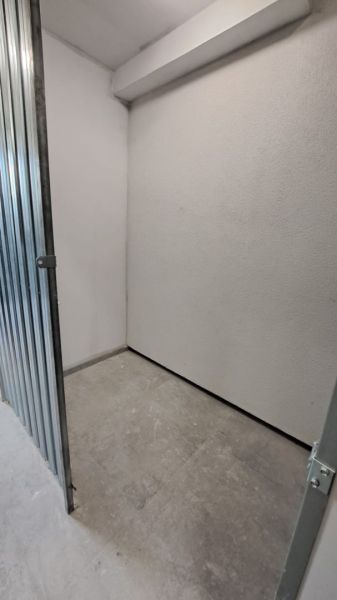 Kis raktárhelyiség fém ajtókkal és betonpadlóval egy kétszobás lakásban.