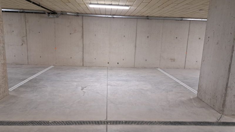 Földalatti garázs betonpadlóval és világítással.