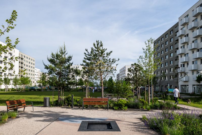 Parkoló övezet padokkal, zölddel körülvéve az Ivanská úton, Pozsonyban, Ružinovban.