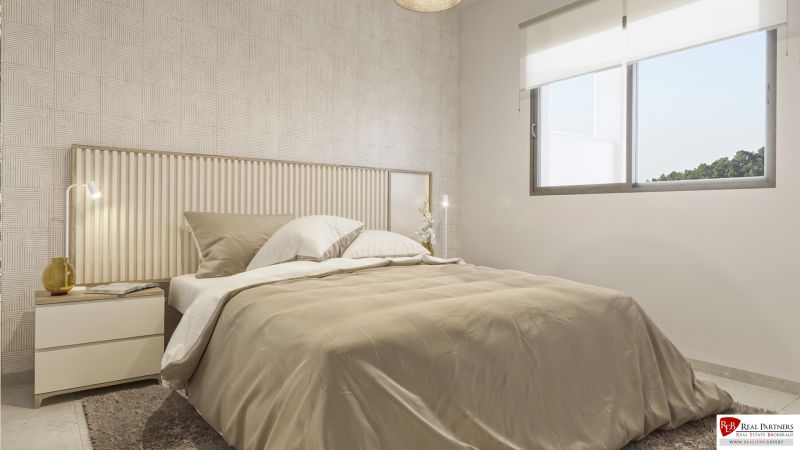 Nyaraló apartman hálószobája ággyal, mintás fallal és nagy ablakkal.