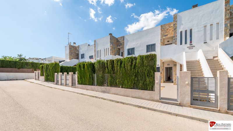Nyaraló apartman Cala Muradában, Mallorcán, sorház beépítéssel, zölddel körülvéve.