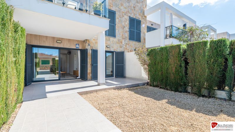 Cala Murada Mallorca-i nyaraló apartman terasszal, kőfalakkal és kerttel.