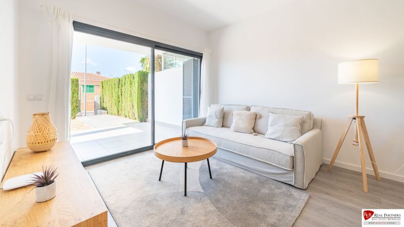 Nyaraló apartman kényelmes kanapéval, asztallal és nagy ablakkal.