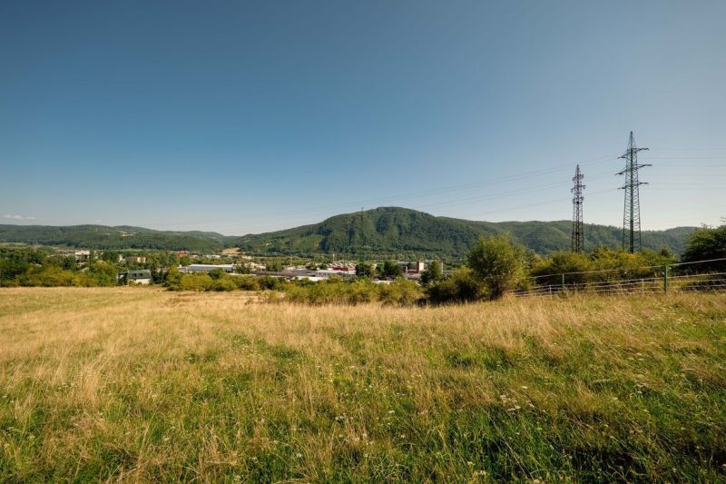 Rét és elektromos oszlopok a Partizánska úton, Besztercebánya. Telkek - lakóövezet.