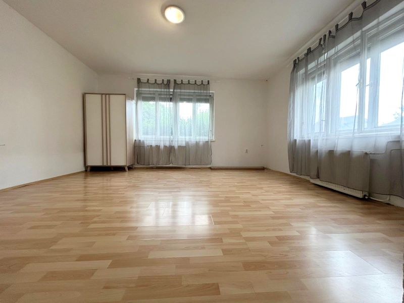 Családi ház belső tere fa dekorációjú padlóval és két ablakkal.