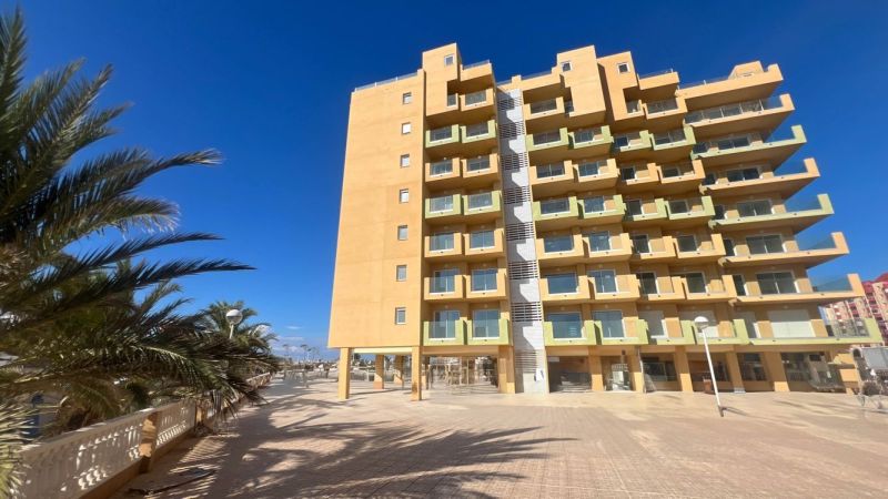 Nyaraló apartman La Manga del Mar Menorban pálmafákkal és derült éggel.