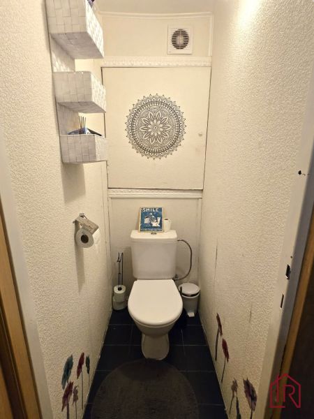 Mennyezeti minta mandalával és tároló kosarakkal rendelkező fürdőszoba egy 4 szobás lakásban.