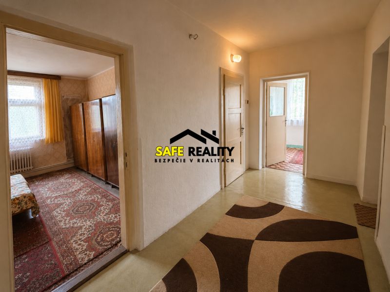 Folyosó a családi házban, szobák bejáratával és szőnyeggel a padlón.