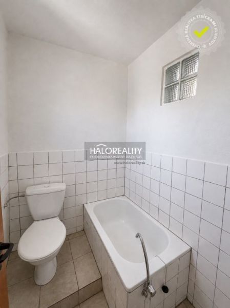 Fürdőszoba családi házban káddal, WC-vel és fehér csempékkel.