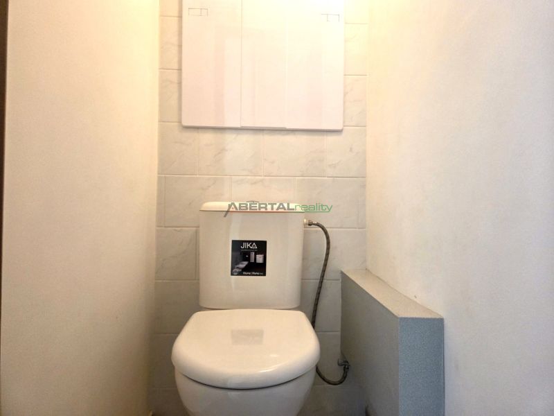 Csempefalú WC egy egyszobás lakásban.