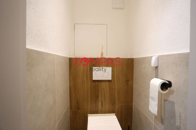 Fürdőszoba egy kétszobás lakásban fa dekor padlóval és WC-vel.