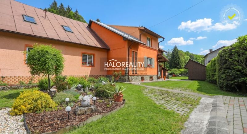 Családi ház Alsómarikóban színes homlokzattal, zöld kerttel és járdával körülvéve.