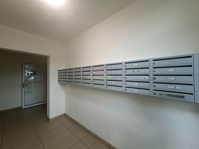 A garzonlakás előszobájában lévő postaládák, csempézett padló, egyszerű dizájn.