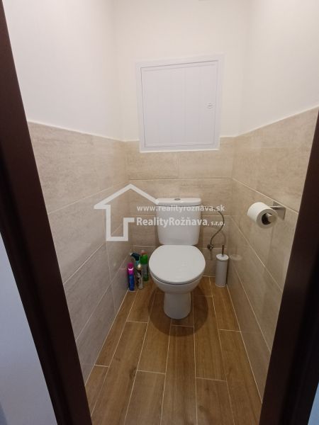 WC fa dekorációjú csempével és padlóval egy háromszobás lakásban.