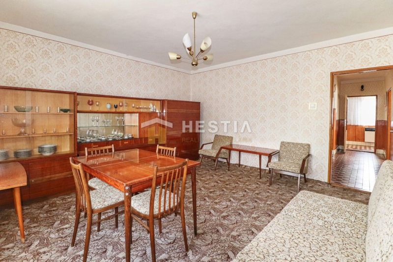 Egy családi ház belső tere 20. századi bútorokkal és mintás szőnyeggel.