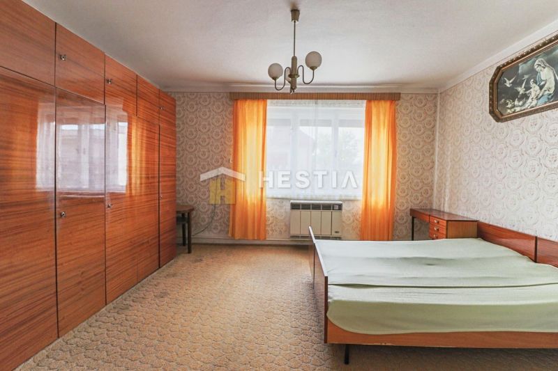 A hálószoba belső tere tapétákkal, szekrényekkel és ággyal családi házban.