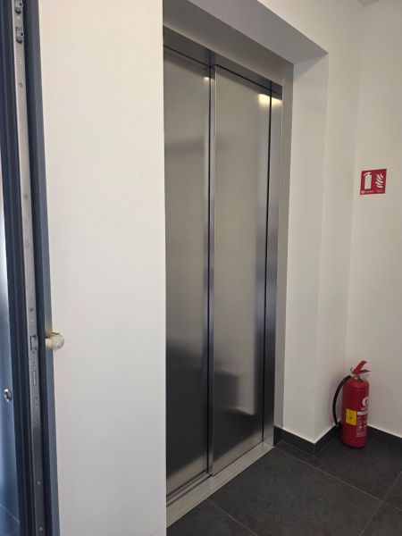 Lift egy négy szobás lakásban csempével és tűzoltó készülékkel.