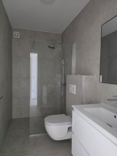 Fürdőszoba zuhanyzóval, mosdóval és WC-vel egy 4 szobás lakásban.