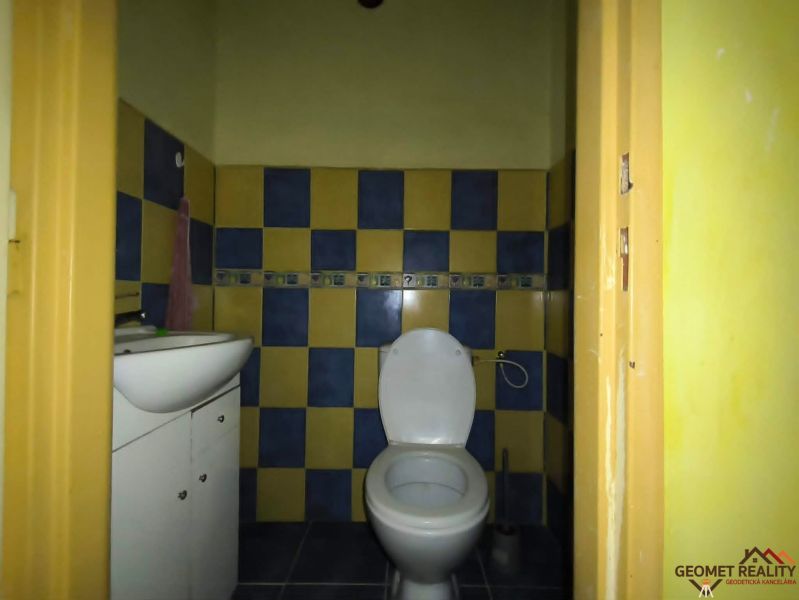 Fürdőszoba mosdóval és WC-vel egy háromszobás lakásban, színes csempék.