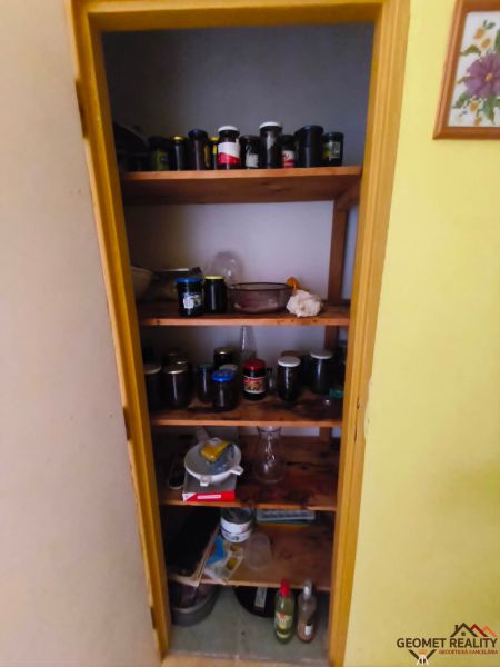 Tárolóhelyiség egy háromszobás lakásban polcokkal és poharakkal.