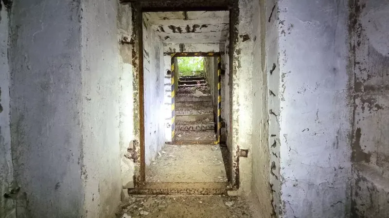 Elhagyatott lépcsőház egy földalatti bunkerben, Különleges ingatlanok Humenné, sérült falakkal.
