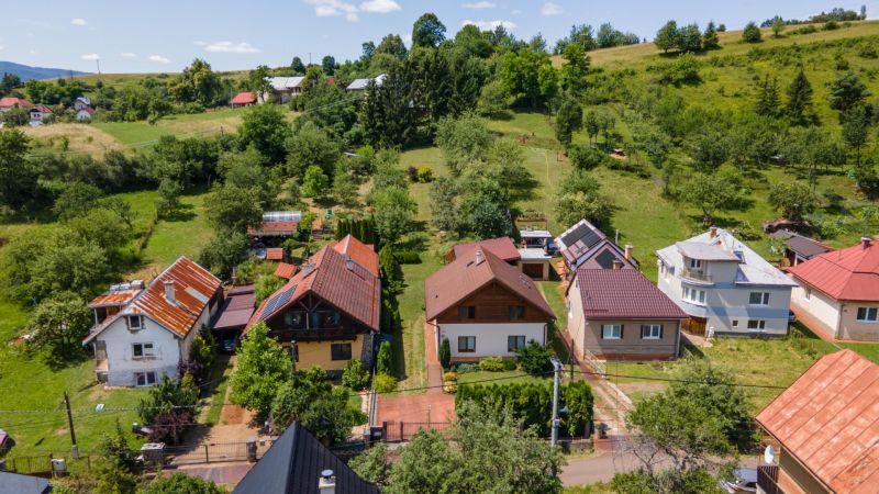 Családi házak Felsőlehóton, zölddel és dombos tereppel körülvéve.