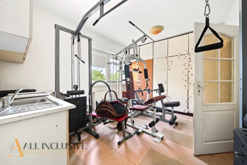 Fitnesz létesítmény családi házban edzőgépekkel és mosdóval.