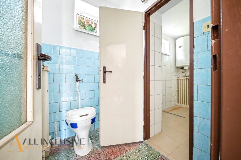 Fürdőszoba családi házban kék csempékkel és különálló WC-vel.