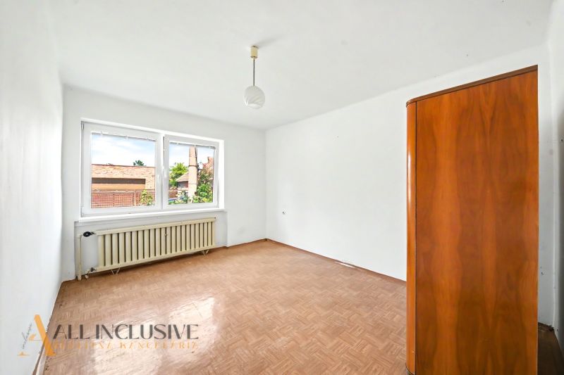 Üres szoba ablakkal, fa dekorációjú padlóval és szekrénnyel egy családi házban.
