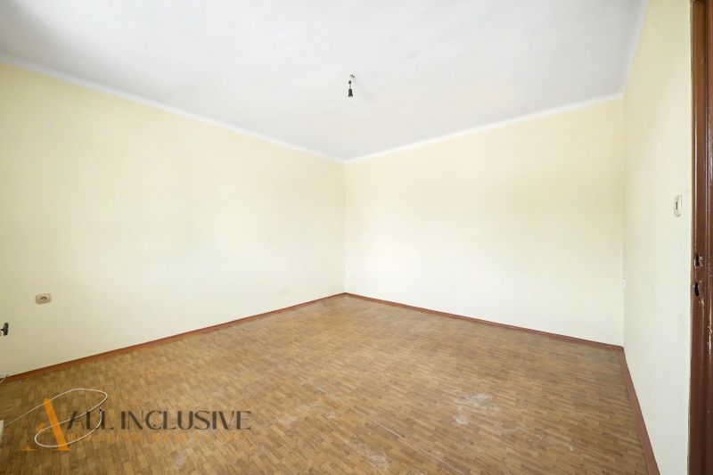 Üres szoba fa mintás padlóval és krémszínű falakkal egy családi házban.