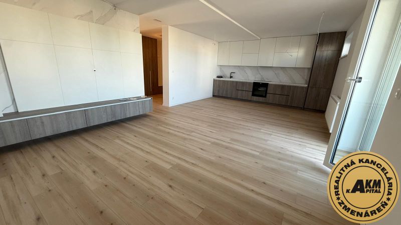 A háromszobás lakás konyhai része fa dekor padlóval és fehér szekrényekkel.