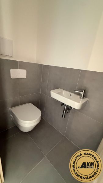 Kis fürdőszoba háromszobás lakásban WC-vel és mosdóval.