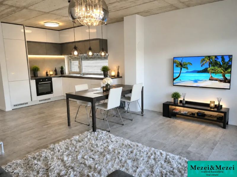 Nappali konyhával, étkezőasztallal és fa dekorációjú padlóval egy családi házban.